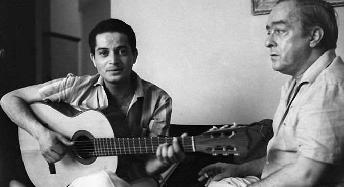 Baden Powell jouant de la guitare à coté de Vinicius de Moraes sur un canapé au Brésil.