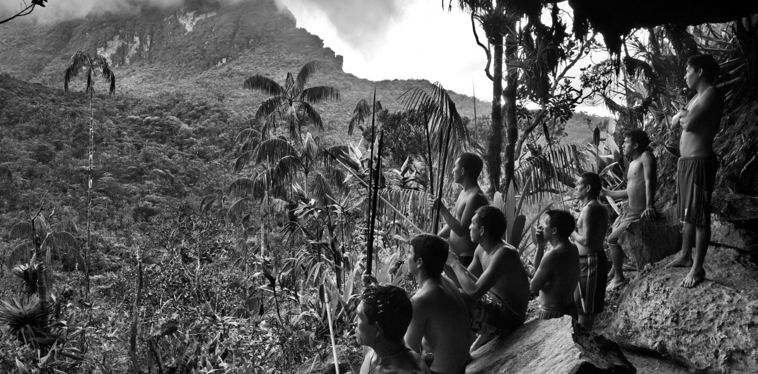 indiens sous une grotte face à la jungle noir et blanc.
