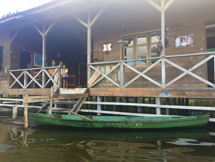 Vue de l'entrée d'une maison flottante avec une barque en Amazonie au Brésil.