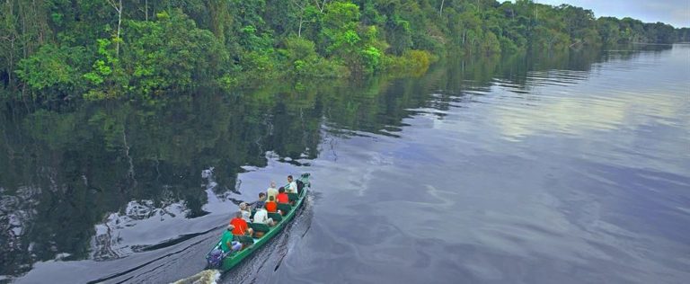 Vue depuis un drone d'une excrusion en canota à moteur sur le Rio negro.