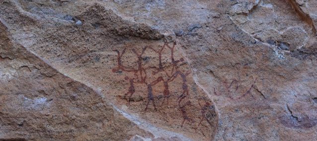 peinture rupestre indigène représentant des silhouettes faisant des acrobaties.