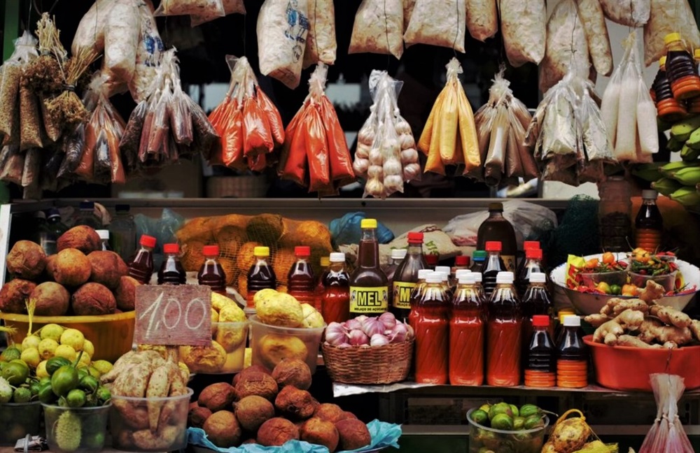 vue frontale d'un étalage de légumes et condiments dans un marché à Bahia au Brésil.